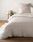 Sand Beige bamboo bedding set on a bed in a bedroom with wooden flooring and a small table