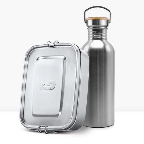 Shiny stainless steel non insulated bottle with a wooden lid and metal handle beside a metal lunch tin