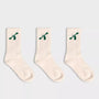 Three pairs of City to Ocean white socks with green designs on a light gray background